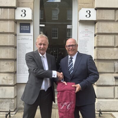Stuart Cutting presented with a red bag by David Lord KC